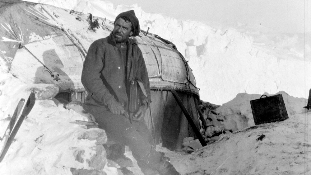 Hurley is seen here outside a makeshift hut that had become home. Courtesy: RGS-IBG