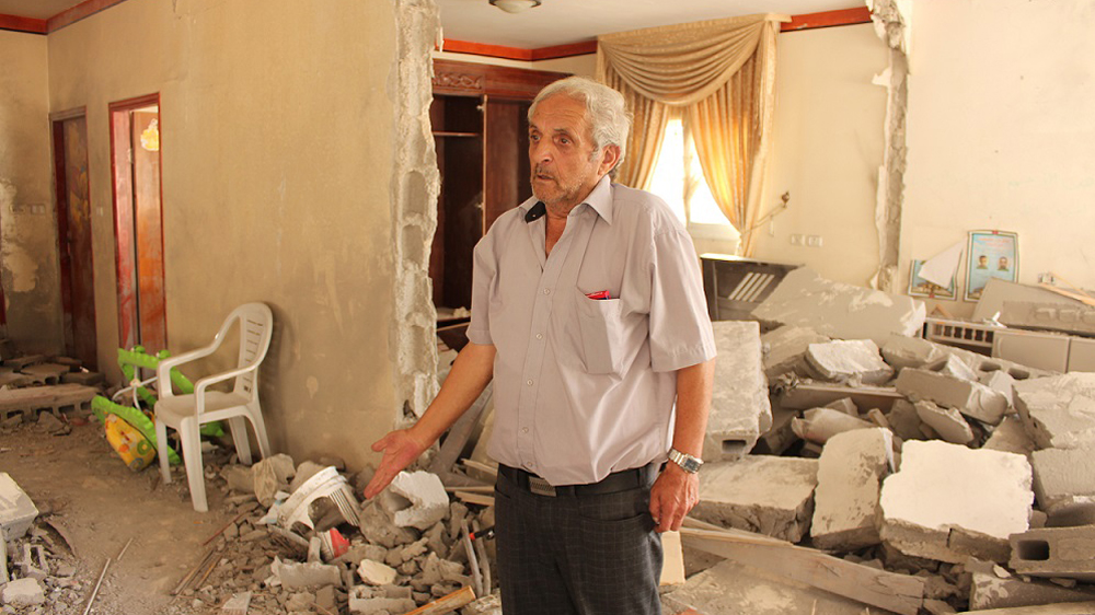 Mohammed Abu Jamal, Alaa's uncle, walks through his son's demolished home in Jabal Mukaber [Nigel Wilson/Al Jazeera]