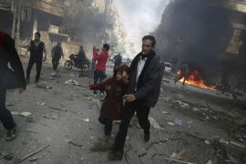 A man holds the hand of a girl as they rush away from a site hit by what activists said were airstrikes by forces loyal to Bashar al-Assad, in Damascus [REUTERS]