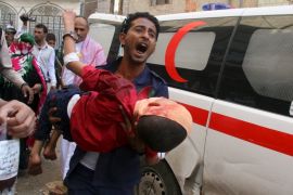 Man shouts as he carries a boy injured by a shell that landed in a residential area during fighting between Houthi militants and pro-government militants in Yemen''s southwestern city of Taiz
