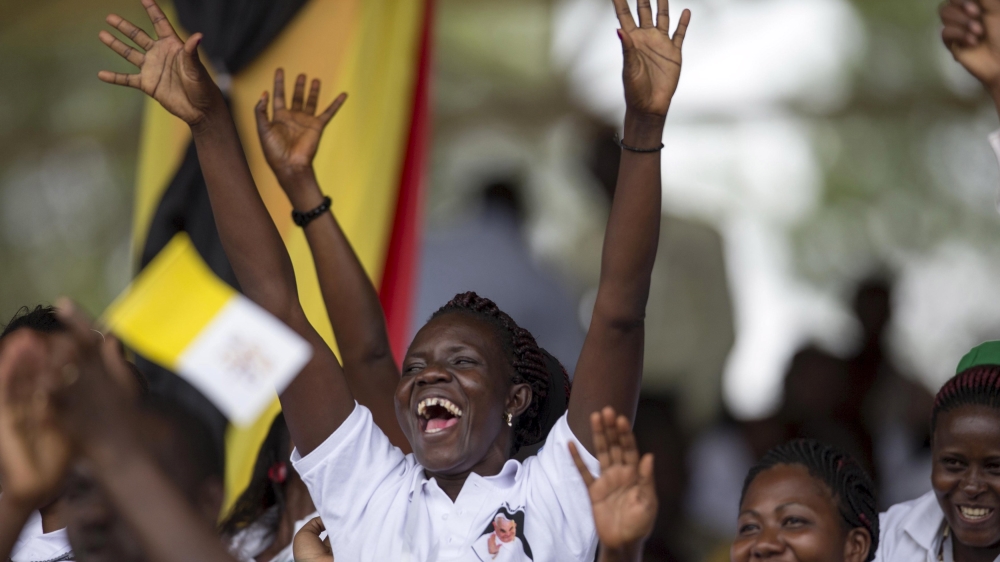 Young people cheer after the pope's arrival at the Kololo ceremonial ground in Kampala [Edward Echwalu/Reuters]