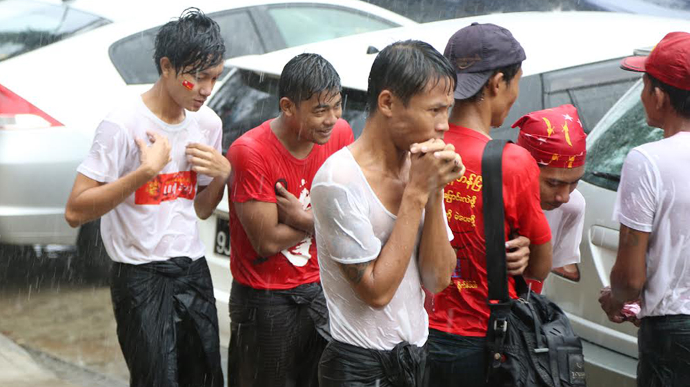 Suu Kyi supporters were soaked in the rain as they waited at the party headquarters, hoping the leader would turn up [Ted Regencia/Al Jazeera]