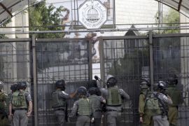 An Israeli border policeman aims breaks into a university