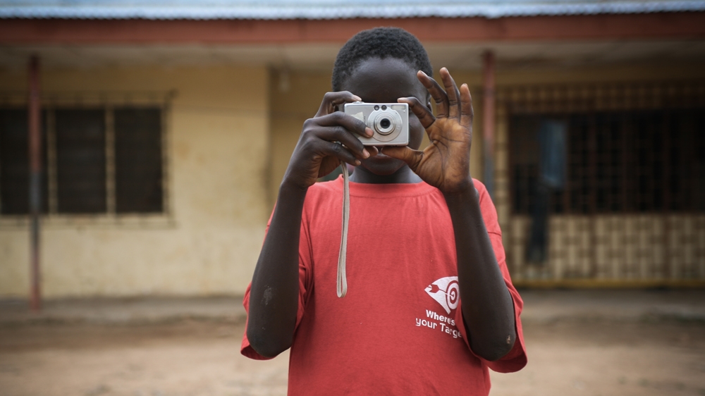 Twenty-year-old Enoch Shaibu says he believes he can travel the world because of his camera [Ruth McDowall/Al Jazeera]
