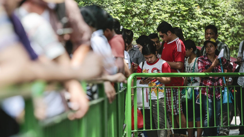  Myanmar expats wait in line to cast their vote outside the Myanmar embassy building in Singapore [Wallace Woon/EPA]
