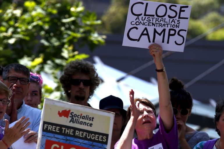 Protesters react as they hold placards and listen to speakers during a rally in support of refugees in central Sydney, Australia