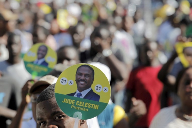 A supporter of presidential candidate Jude Celestin holds a sign during a demonstration to protest against the electoral process in Port-au-Prince, Haiti