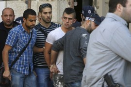 Israeli policemen detain a Palestinian suspect in a construction site near the area where he stabbed a woman in Jerusalem, a police spokesman said, the latest attack in a two-month wave of violence
