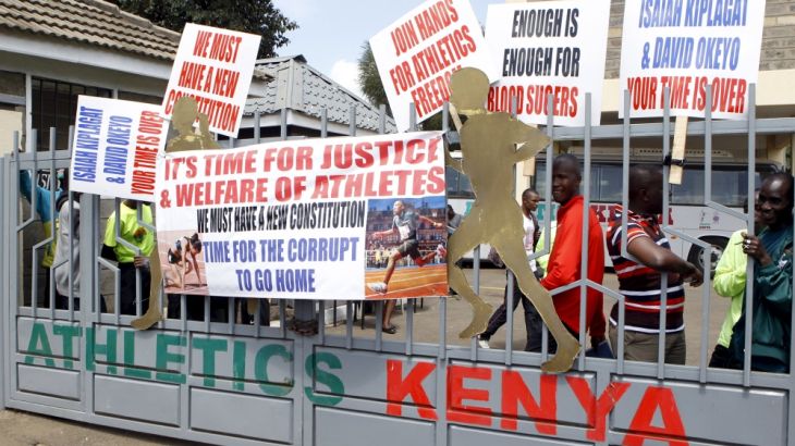 Protesting Kenyan athletes place placards behind closed gates at Riadha House the Athletic Kenya Headquarters in capital Nairobi