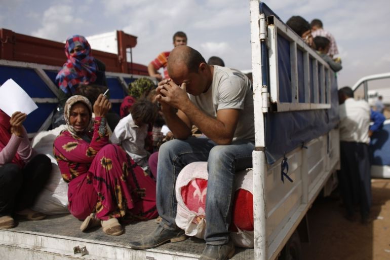 File photo of Syrian Kurdish refugees sitting in a truck after crossing the Turkish-Syrian border near the southeastern town of Suruc in Sanliurfa province