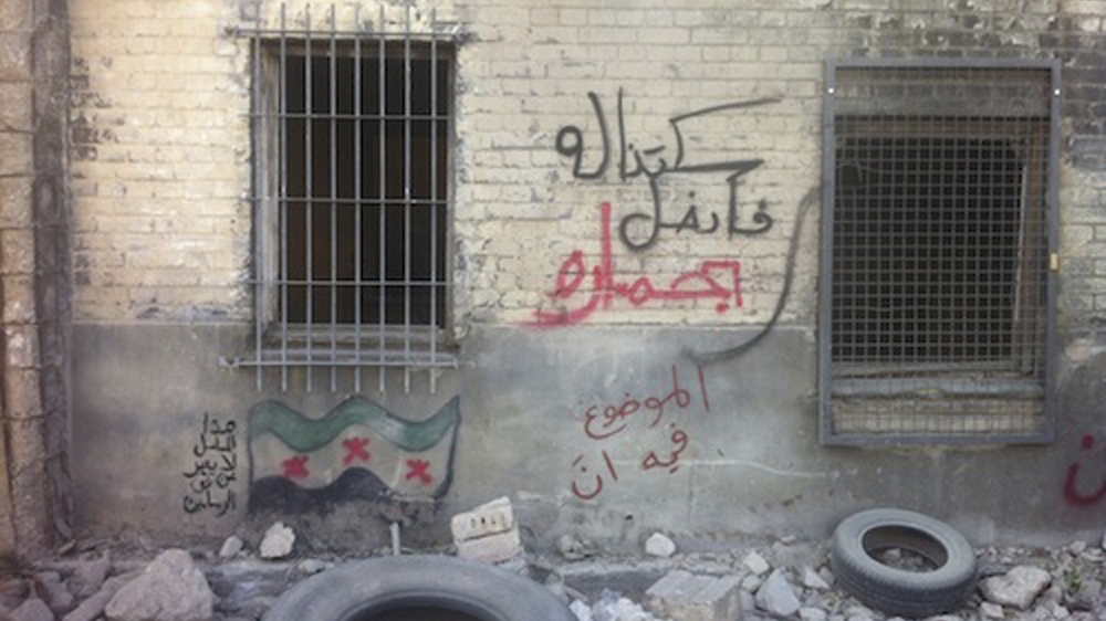 Graffiti on the wall translates to: 'We didn't resist, so he conquered us riding on a donkey; bottom:' The situation is not to be trusted'; left, 'This show does not represent the views of the artists', on the set of Homeland in Berlin, Germany [Courtesy of Heba Amin via AP]