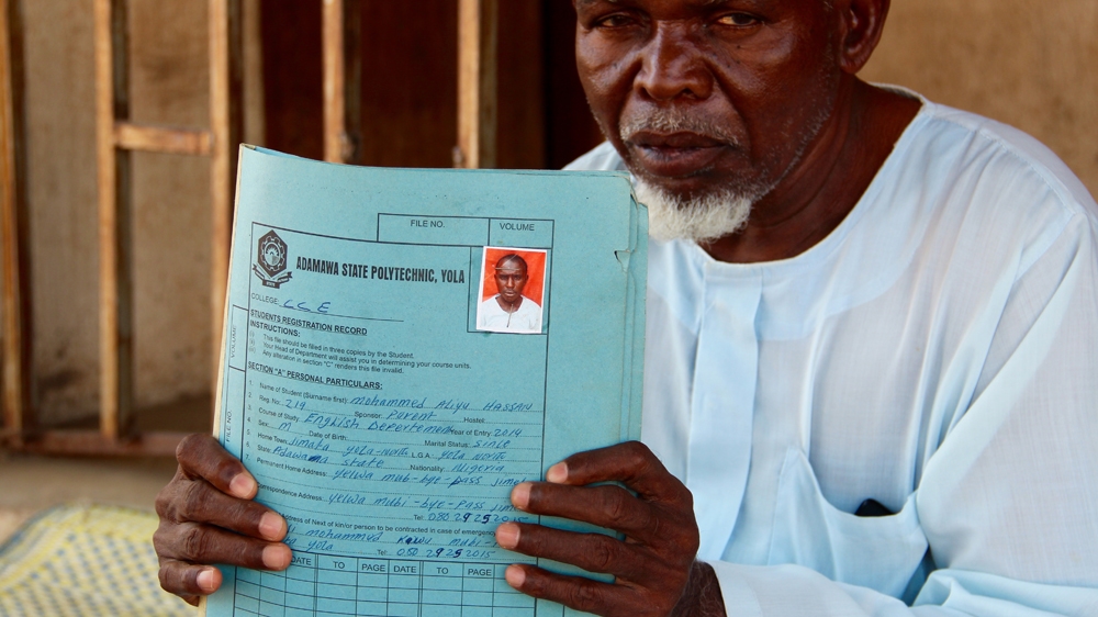 Mohammed shows his son's student registration file for the Adamawa State Polytechnic where he studied [Femke van Zeijl/Al Jazeera]