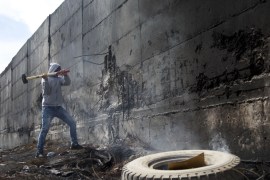 A Palestinian student tries to break the separation barrier