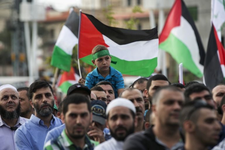 Israeli-Arabs hold Palestinian flags during a pro-Palestin