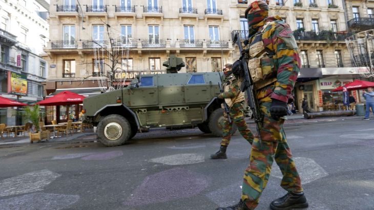 Belgian soldiers patrol in central Brussels as police searched the area during a continued high level of security following the recent deadly Paris attacks
