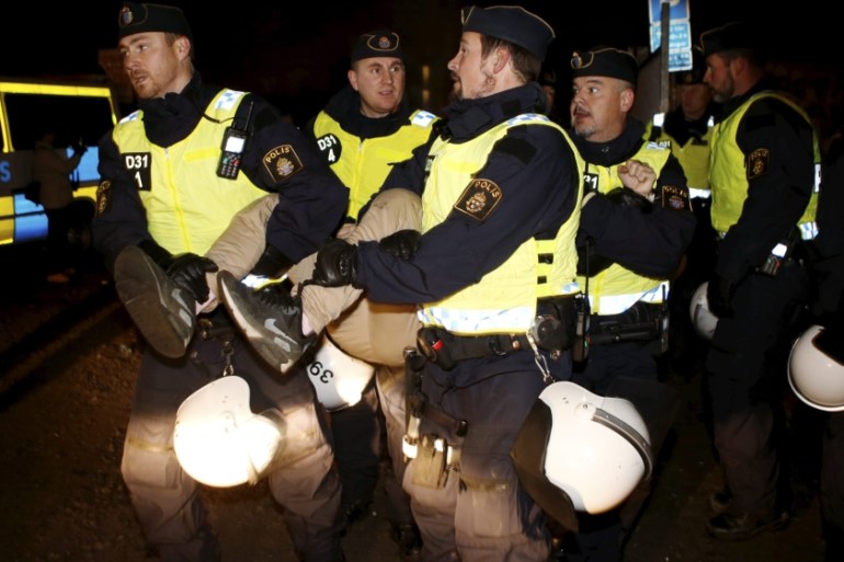 Police officers evict migrants from an illegal camp in Sweden