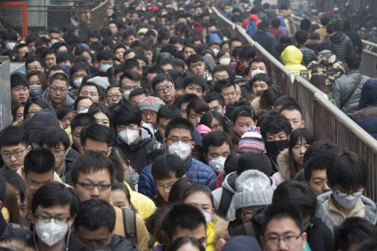 Morning commuters wait in line at the Tiantongyuan subway station on a smoggy day after the city issued its first ever "red alert" for air pollution, in Beijing