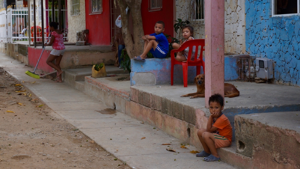 Children sit on the front terraces of the houses in the City of Women [Julia Zulver/Al Jazeera]