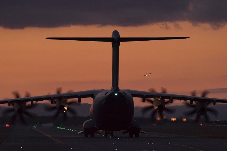 A fighter jet in the background landing as a transport aircraft is seen on the ground at the RAF Akrotiri, a British air base near the coastal city of Limassol, Cyprus [AP]