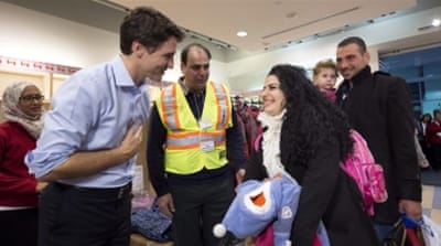 Prime Minister Justin Trudeau greets refugees fleeing from Syria, as they arrive at Pearson International airport, in Toronto [AP] 