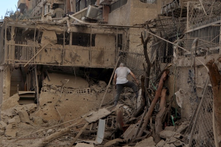 A man walks on debris at a site hit by what activists said were barrel bombs thrown by forces loyal to Syria''s President Bashar Al-Assad, in the Palestinian Yarmouk refugee camp