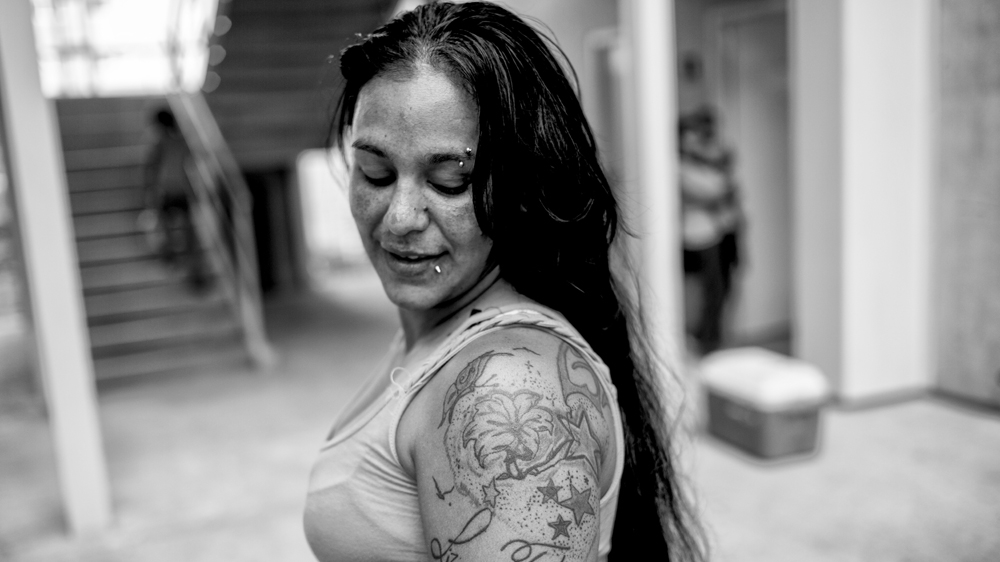 Lisbeth poses for a portrait displaying the tattoos that were the work of her tattoo artist boyfriend, Ender [Alejandro Cegarra/Al Jazeera]