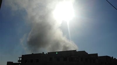 Smoke rises from a residential building in Saqba, in the outskirts of Damascus [Norran K/Al Jazeera]