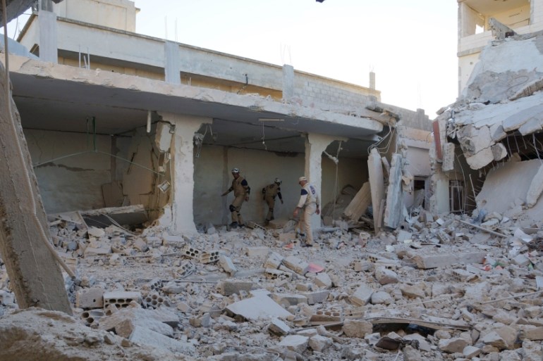Civil defence members inspect a site hit by what activists said were airstrikes carried out by the Russian air force in Sheikh Meskeen near Deraa