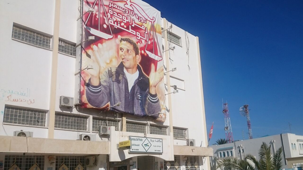 The government building in front of which Mohamed set himself aflame is adorned with his picture and the words '17 December revolution. Symbol of national unity' [Thessa Lageman/Al Jazeera]