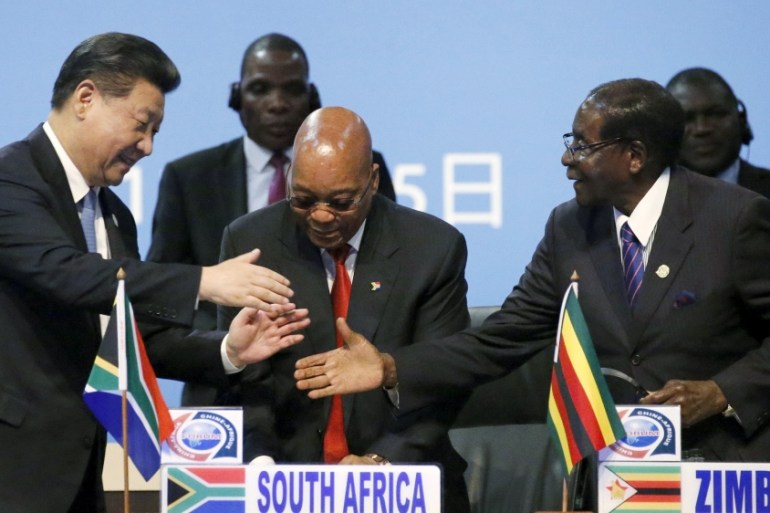 Xi shakes hands with Mugabe in Sandton