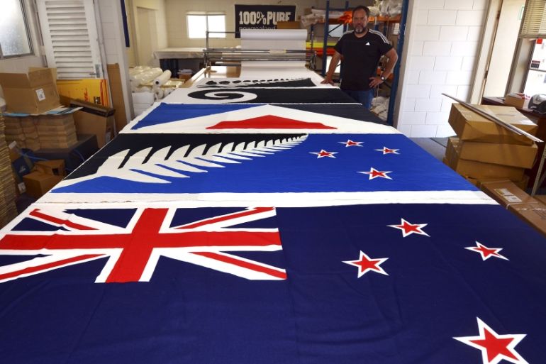Factory worker Dion Williams looks at new designs of the national flag of New Zealand laid out on a table at a factory in Auckland, New Zealand
