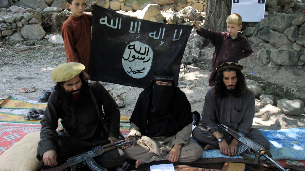 A picture made available in August shows an ISIL leader sitting with colleagues and his family at an undisclosed location in Kunar province, Afghanistan [File: EPA]