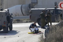 Israeli troops inspect scene where Palestinian, who the Israeli military said attempted to stab Israeli security forces with screwdriver, was shot dead at a checkpoint near Hebron