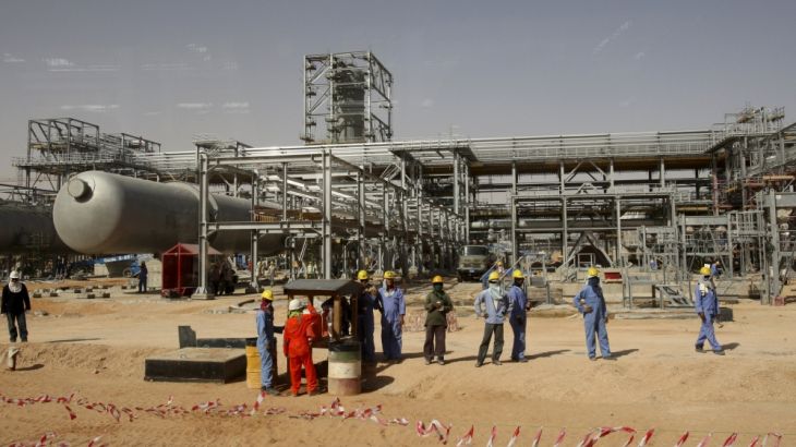 File photo of workers looking at journalists during a media tour of the Khurais oilfield