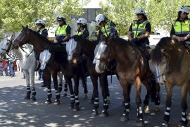 Police sit atop horses and stand guard as they watch members of the left-wing coalition and right-wing activists from the United Patriots Front in the town of Bendigo, located in the st