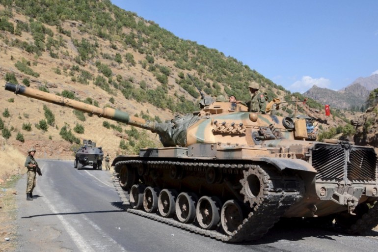 Turkish soldiers in a tank and an armored vehicle patrol on the road to the town of Beytussebab in the southeastern Sirnak province, Turkey