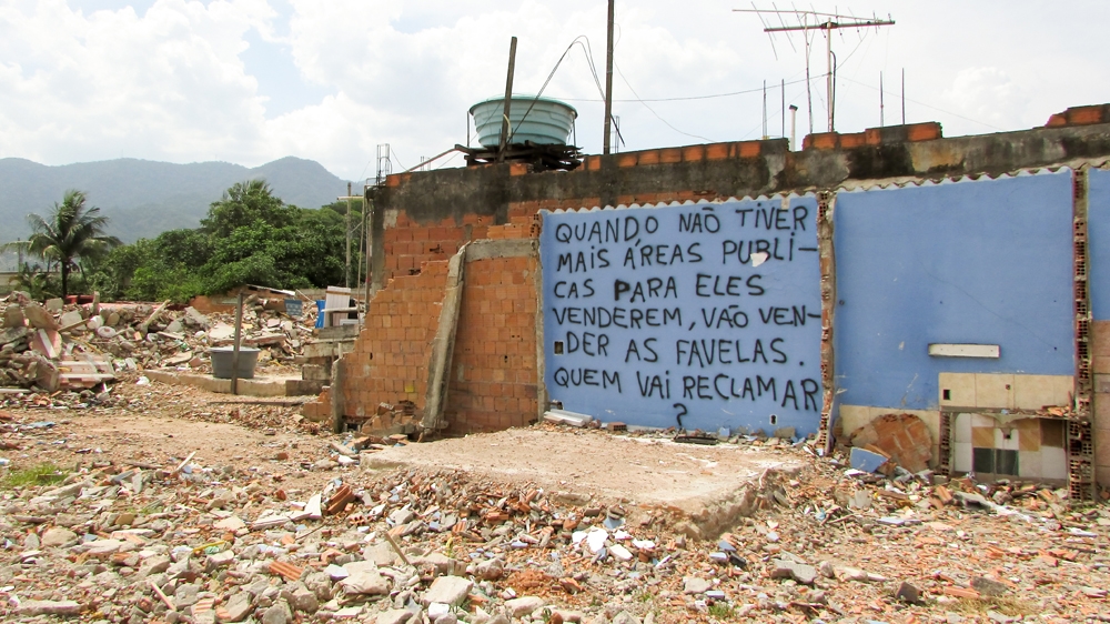The message reads: 'When there are no more public areas for them to sell, they will sell the favelas. Who is going to complain?' [Maya Thomas-Davis/Al Jazeera]