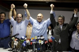 Secretary of Venezuela''s coalition of opposition parties holds hands with deputies Borges and Ramos Allup during a news conference in Caracas