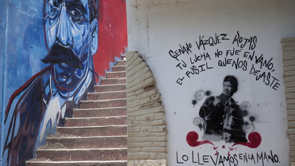 A painting at Ayotzinapa's teacher training college reads: 'Genaro Vazquez Rojas [a rebel leader] your fight was not in vain, the gun you left we took in our hands' [Eduardo Miranda/Al Jazeera]