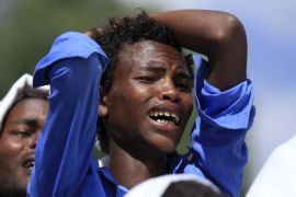 A man mourns during the funeral ceremony of Dinka Chala a primary school teacher who family members said was shot dead by military forces during a recent demonstration in Holonkomi town in Ethiopia
