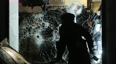 A hooded man walks past a destroyed shopping window in Leipzig, Germany, 11 January 2016 [Jan Woitas/EPA]