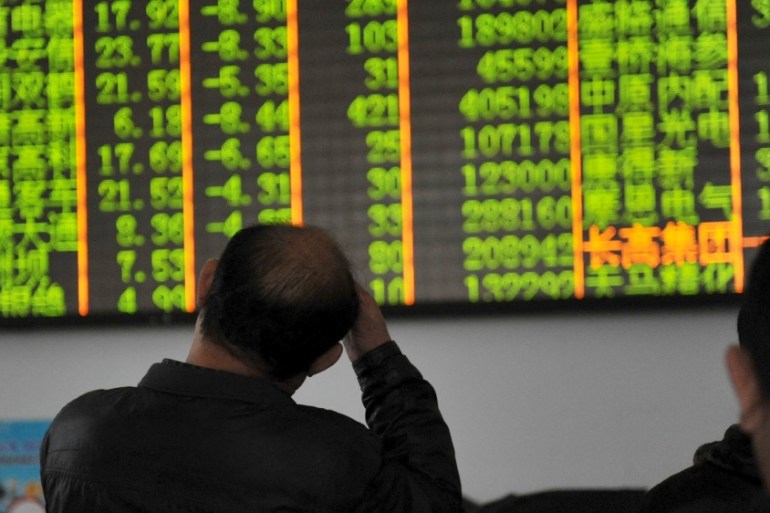 Investors look at an electronic screen showing stock information at a brokerage house in Hangzhou