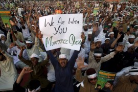 A supporter of the Ahle Sunnat religious political group holds a sign in support of convicted killer Mumtaz Qadri during a sit-in protest demanding his release in Karachi, Pakistan