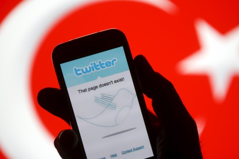 File illustration of a person holding a Samsung Galaxy S4 displaying a Twitter error message in front of a Turkish flag