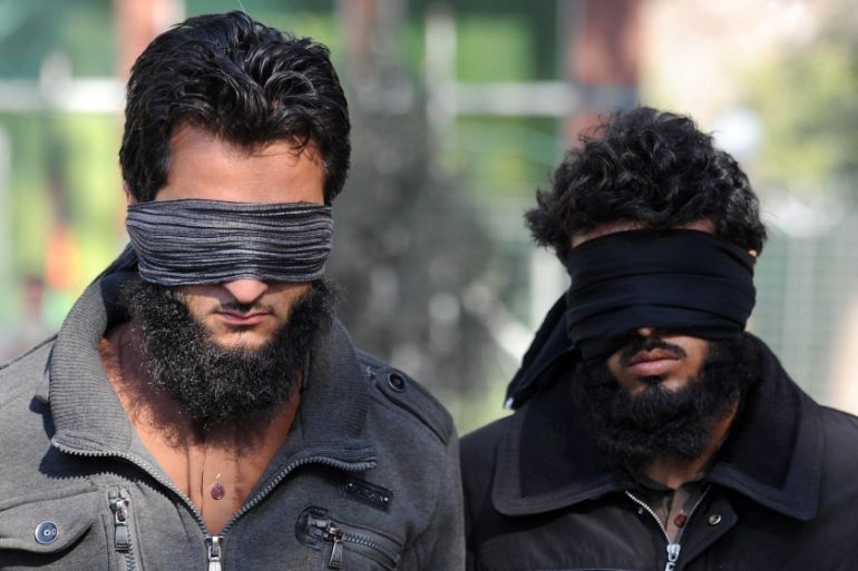 Afghan security officers escort two of six alleged members of the group calling themselves ISIL, arrested after clashes with Afghan security forces in Nangarhar province, Afghanistan [EPA]