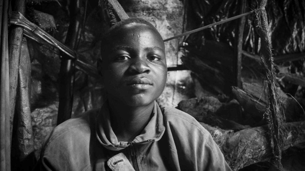 Sixteen-year-old miner Inocence must walk for an hour to reach his post at the Rubaya coltan mine. 
