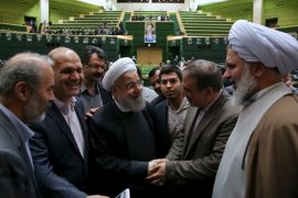 Iranian President Hassan Rouhani is greeted during a session in Tehran