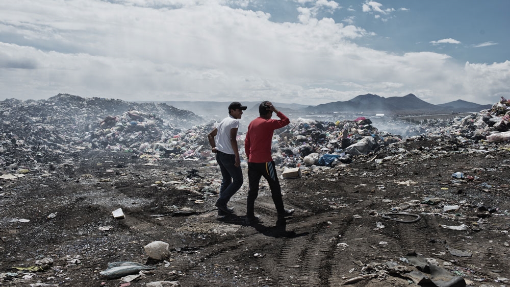 The Quispe brothers talk and trawl through the rubbish dump looking for materials to bring home [Valentino Bellini/Al Jazeera]