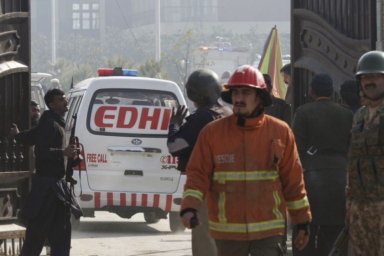 Soldiers and rescue workers stand as an ambulance enters Bacha Khan University, after a militant attack at the university, in Charsadda