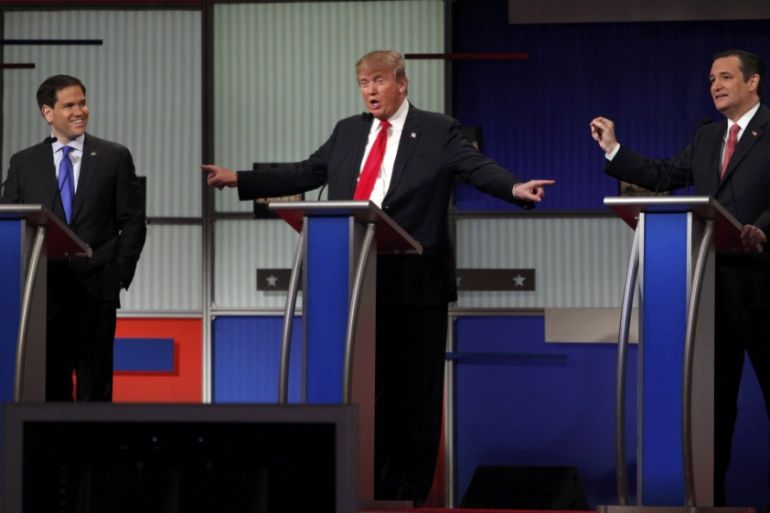 Republican U.S. presidential candidate Trump gestures towards rivals Rubio and Cruz during the Fox Business Network Republican presidential candidates debate in North Charleston